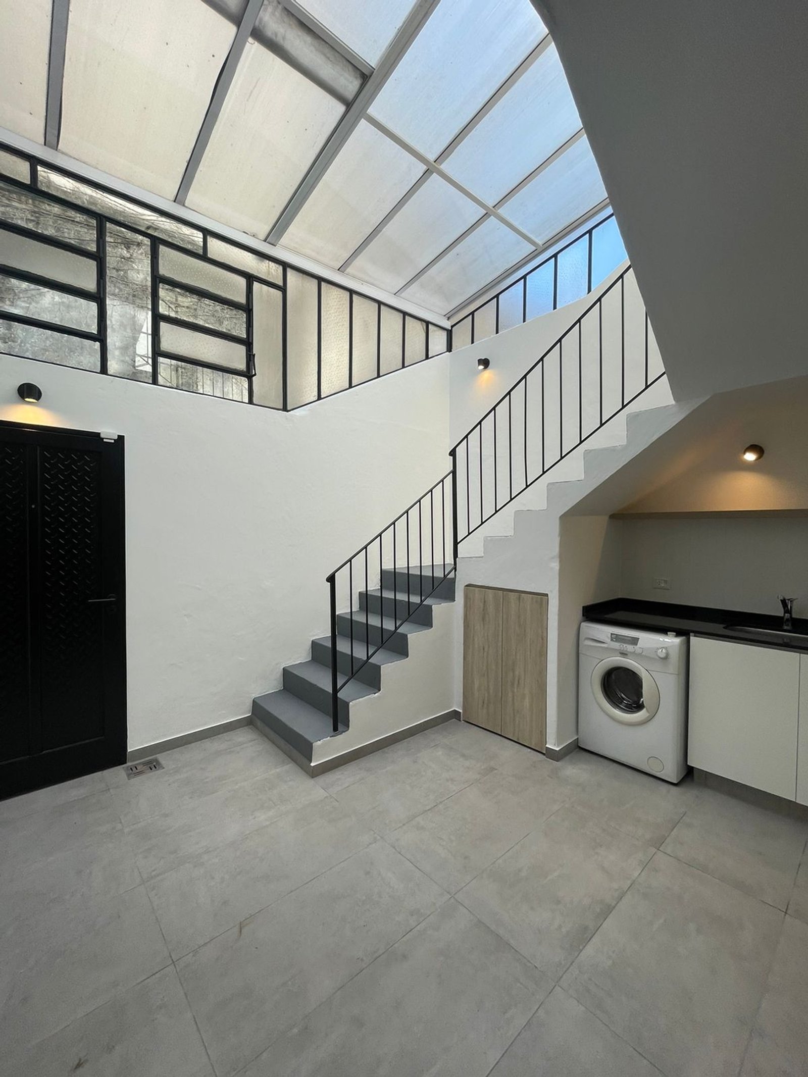 Escada flutuante moderna com teto de vidro e piso de pedra cinza — projeto Carranza, por Estudio NET Arquitectura, em Adolfo P. Carranza 2263